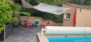 eine Terrasse mit Stühlen und einem Tisch neben einem Pool in der Unterkunft Appartement à La Bastidonne in La Bastidonne