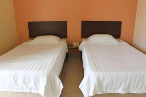 two beds sitting next to each other in a room at THE GARDEN HOTEL (BANTING) SDN. BHD. in Banting