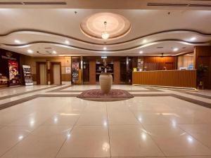 a lobby with a vase in the middle of a building at Putra Brasmana Hotel in Kangar