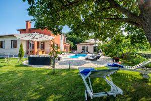 Un patio con piscina y una casa. en Villa Ivona, a luxurious villa minutes from the sea, en Labin