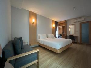 ジョホールバルにあるMIYABI HOTEL PERMASのベッドとソファのあるホテルの部屋