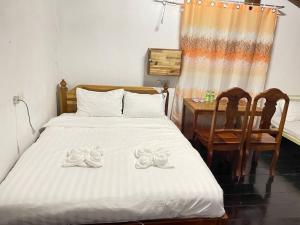 a bedroom with a bed and a table and chairs at Sousada Guesthouse in Luang Prabang