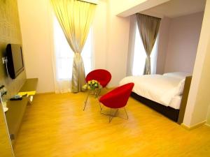 a bedroom with two red chairs and a bed at Sri Manja Boutique Hotel in Kuantan