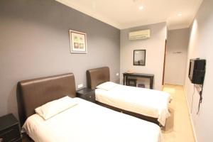 a hotel room with two beds and a television at Hotel Station 18 in Kampong Kuala Punti +96 photos