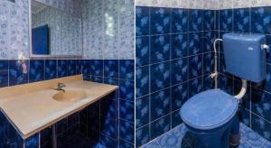 a blue tiled bathroom with a toilet and a sink at OYO 89646 Panvill Resort in Pasir Bogak +61 photos