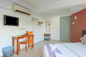 a bedroom with a bed and a desk and a table at OYO 89874 Gs Golden Star Hotel in Seri Kembangan