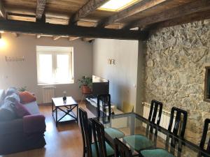 a living room with a couch and a stone wall at alojamiento Costa Quebrada in Santa Cruz de Bezana