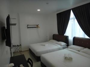a hotel room with two beds and a window at Hotel Seri Geliga in Kampong Geliga Besar +115 photos
