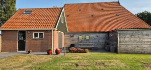 a house with a cat sitting in front of it at Alpaca World Friesland in Workum