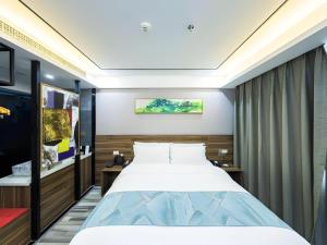 a bedroom with a large bed in a room at Borrman Hotel Zhenjiang Dashikou Suning Plaza in Zhenjiang