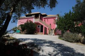 ein rosa Haus mit Treppen in einer Einfahrt in der Unterkunft Arpyia in Vasilikos