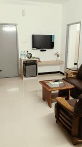 Una sala de estar con un sofá y una mesa de café. en Nortels Heights Hotel Apartments, en Chennai