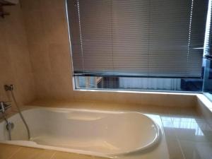 a white bath tub in a bathroom with a window at Grand Barakah Hotel in Kuala Lumpur