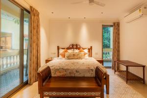 a bedroom with a bed and a large window at 5-BHK Villa With Common Pool & Lift Near Beaches in Majorda
