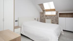 カルバージョにあるAG Ático dAmalia Carballoの白いベッドと窓のある寝室