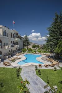 a resort with a swimming pool and lounge chairs at Uchisar Kaya Otel in Uchisar