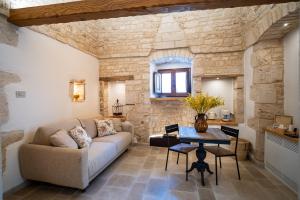 a living room with a couch and a table at Dimore Piazza Roma Trulli & Suite in Alberobello