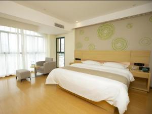 a bedroom with a large white bed and a chair at GreenTree Inn Chaohu High Speed Rail East Station in Chaohu