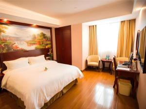a hotel room with a large bed and a desk at GreenTree Inn Shanghai Waigaoqiao Free Trade Zone Express Hotel in Shanghai +152 photos