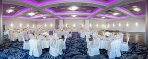 a banquet hall with white tables and purple ceilings at Hotel Sękowski in Legnica