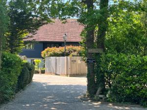 a house with a street sign on a tree at Amber Lodge Hickstead-B in Haywards Heath