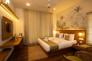 a hotel room with a bed and a desk at Bamboo Dale Resort & Spa Munnar by Stride in Munnar