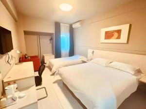 Un ou plusieurs lits dans un hébergement de l'établissement Jinjiang Inn Harbin Qunli Metro Supermarket Airport Bus Station 71 autres photos