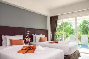 a hotel room with two beds with towels on them at Amin Resort in Ban Thalat Choeng Thale