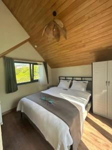a bedroom with a large bed with a wooden ceiling at Newrose hotels in Kemalpasa +104 photos