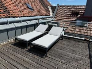 two chairs sitting on top of a wooden deck at Klimatisierte Luxus-Dachterrassenwohnung im Zentrum in Sankt Pölten