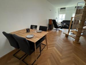 a wooden table and chairs in a living room at Klimatisierte Luxus-Dachterrassenwohnung im Zentrum in Sankt Pölten