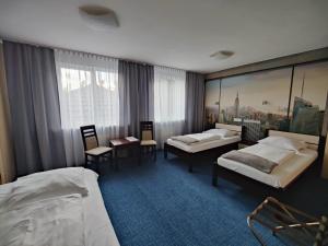 a hotel room with two beds and a large window at Hotel City in Koszalin