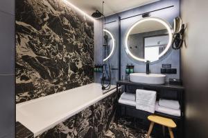 a bathroom with a sink and a mirror at voco Katowice by IHG in Katowice