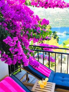 a balcony with pink flowers and a bench and a tree at Villa Mila in Korčula Town in Korčula