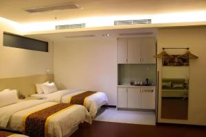 a hotel room with two beds and a kitchen at Guangzhou Hailian Hotel - Haizhu District Binjiang East Road Metro Station in Guangzhou