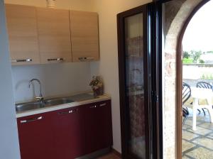 a kitchen with a sink and a door to a patio at Villa Matine in Specchia +18 photos