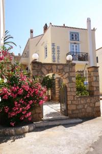 a building with a gate and pink flowers at Kastro Hotel in Spetses
