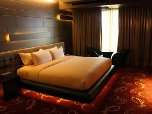 a hotel room with a bed and a window at Maleewana Hotel & Resort in Bang Yai