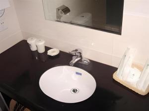 a bathroom counter with a white sink and a mirror at GreenTree Inn Linyi Bus Station in Linyi +32 photos
