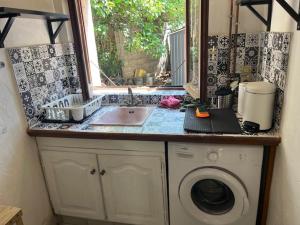 a kitchen with a sink and a washing machine at Studio meublé Fréjus équipé d'une climatisation in Fréjus