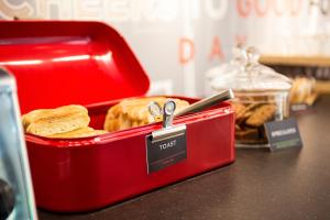 a red lunch box with bread and a pair of scissors at ibis Amsterdam Centre Stopera in Amsterdam