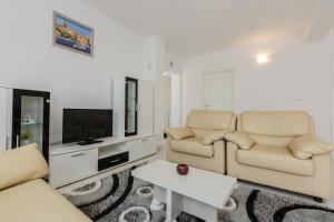 a living room with two couches and a tv at Apartment Anna in Kaštela