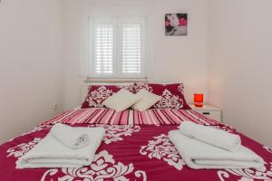 a bedroom with a purple bed with towels on it at Apartment Anna in Kaštela