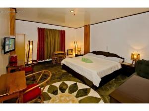 a bedroom with a bed and a table and chairs at OYO 880 Flores De Musa Inn in Puerto Princesa City