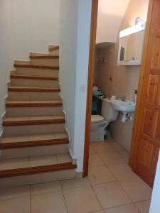 a bathroom with a staircase with a toilet and a sink at Casa a 5 minutos playa Riells in L'Escala