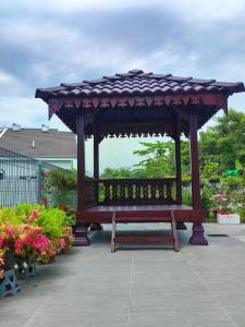 a wooden bench with a gazebo in a garden at 2Op Ipoh, Semi D, in Ipoh