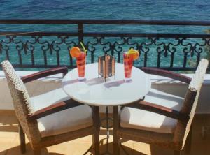 a white table with two drinks on a balcony at Kekrifalia Hotel in Skala
