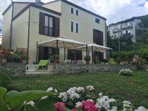 LongiにあるAntico Borgo San Francescoの緑の椅子と花の庭のある家