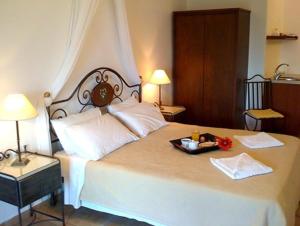 a large white bed with a tray of food on it at Kekrifalia Hotel in Skala