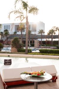 a plate of food on a table next to a pool at Zahara Beach & Spa by QHotels - Adults Recommended in Zahara de los Atunes
